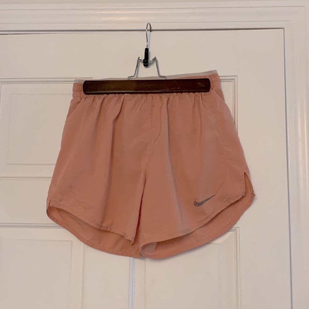 This is a pinkish coral colored pair of running shorts from Nike.